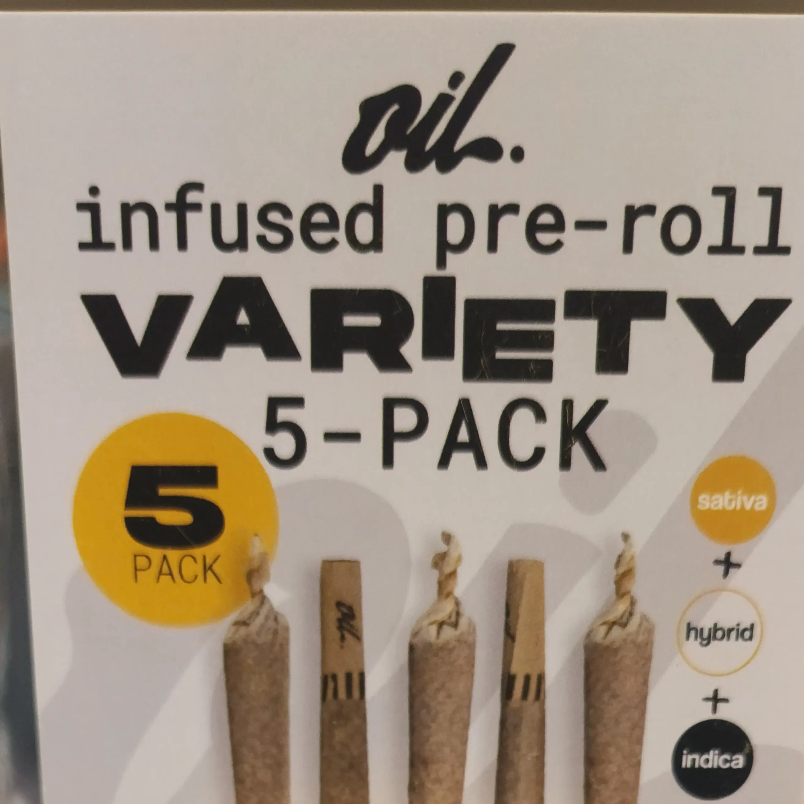 An image of a packaging for a 5-pack of oil-infused pre-rolls labeled "Variety" with sativa, hybrid, and indica options.